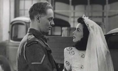Bride and groom in vintage military attire.