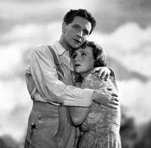 Black and white couple embracing, looking worried.